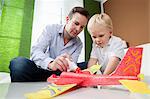 Father and son fixing toy plane