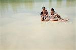 Mother and daughters play in a lake