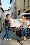 Couple moving sofa in street