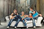 Group relax on couch laughing in street