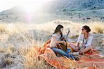 Femme jouant de la guitare dans l'herbe