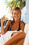 Girl relaxing on sun bed with champagne