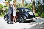 Bridal couple in front of car