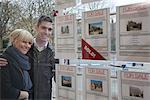 Couple looking into estate agents window