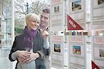 Couple looking into estate agents window