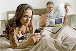 Young woman using smart phone on bed