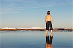 Garçon et permanent de réflexion sur la plage