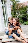 Mother and daughter hugging on patio