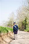 Boy in cap on dirt road