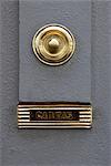 Madeira. Detail of bBrass doorbell and letterbox on grey front door