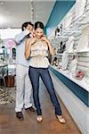 Man Helping Woman Try on Necklace in Store