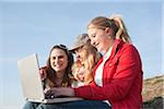 Teenagers using Laptop Outdoors