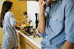 Couple together in kitchen, woman cooking