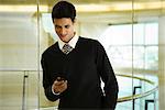 Businessman text messaging with cell phone