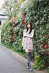 Young Trendy Girl Standing Near Plants