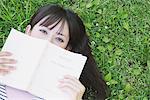 Young Woman Covering Her Face With A Book