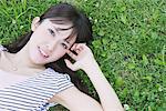 Young Woman Lying On A Grassy Field