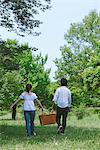 Couple Walking in Park Holding Basket