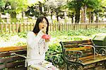 Jeune femme assis sur un banc et repas