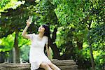 Junge Frau im Park Holding Glas Wasser