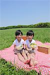 Twins Eating Lunch Together in Park