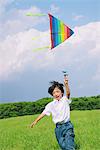 Boy Running Holding Kite in Park