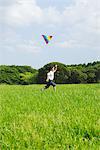 Boy Running Holding Kite in Park