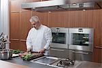 Mid- adult chef prepares salad