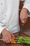 Mid- adult chef cutting carrots