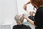 Stylist cuts elderly woman's hair