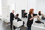 Stylists cut clients' hair in unisex salon
