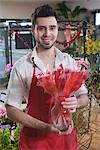 Fleuriste se dresse avec fleurs rouges séchés