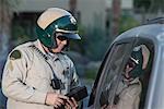 Patrol officer stands at window of luxury car