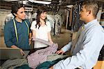 Man and woman serving a customer in the laundrette