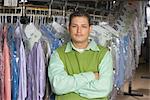 Mann arbeitet in der Laundrette, ständigen infront von Kleidung Schiene