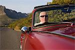 Senior homme dans la voiture de course vintage sur Signal Hill, Cape Town, Afrique du Sud