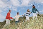 Family walking hand in hand over dune