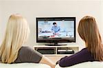 Two young women watching television