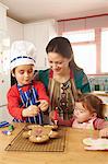 Mother cooking with children in kitchen