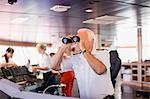 Captain on ship looking through a telescope