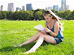 Woman reading a letter in central park