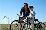 Father and son with bikes by a windfarm