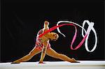 Young acrobat performing gymnastics with ribbon