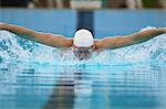 Young adult man swimming butterfly stroke