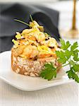Scrambled eggs,spring garlic and shrimps on a bite-size slice of bread