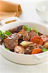 Small casserole dish of lamb and carrot stew with oregano