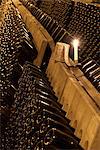 Rows of wine bottles on racks in a cellar