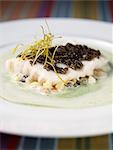 Bass fillet with oysters,caviar,fried leeks and parsley cream sauce