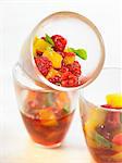 Summer fruit with orange juice and rose petals