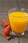 Glass of orange juice,organic chocolate biscuits and a strawberry